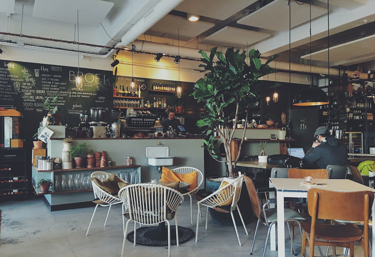 Cafe interior — espresso bar, chalkboard menu, seated customers
